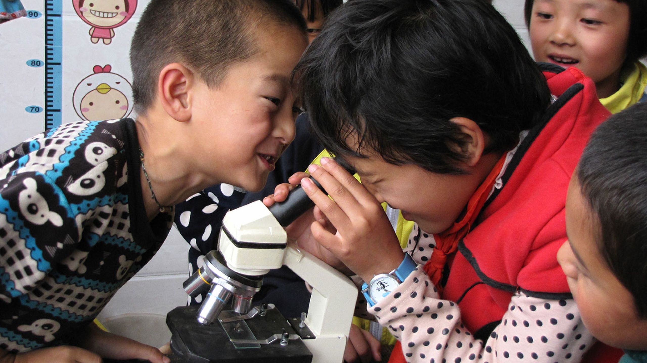 children looking in microscope